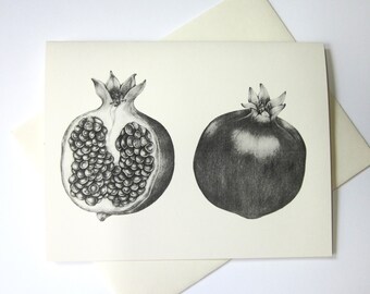 May include: A cream-coloured greeting card with a black and white illustration of a pomegranate. One pomegranate is whole, the other is cut open, showing the seeds. The card is on a cream background.