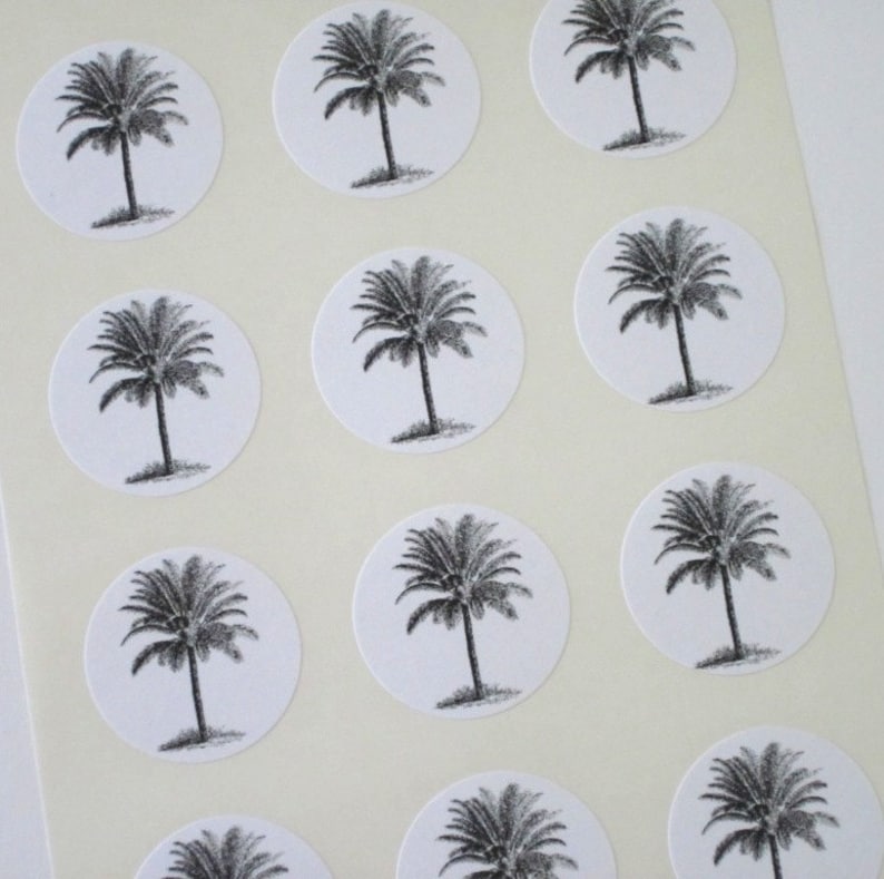 Puede incluir: Hoja de pegatinas blancas con ilustraciones de palmeras negras. Cada pegatina es un c&iacute;rculo con una palmera en el centro.