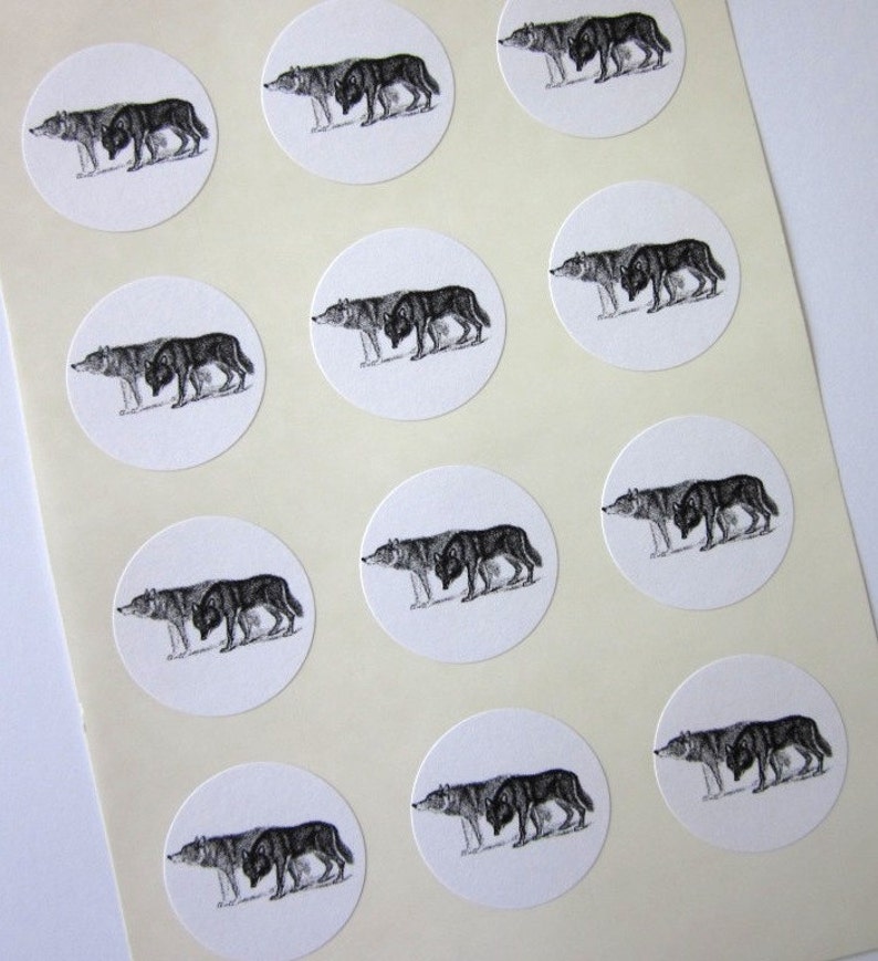 May include: A sheet of white paper with 12 black and white wolf stickers. Each sticker is a circle with a wolf illustration.