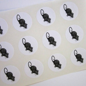 Peut inclure: Une feuille de papier blanc avec douze autocollants de rats noirs et blancs. Chaque autocollant est un cercle avec une illustration de rat noir sur fond blanc.