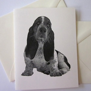 Könnte beinhalten: Schwarzweiß-Illustration eines Basset Hounds, der sitzt und den Kopf leicht zur Seite geneigt hat. Der Hund hat große, herabhängende Ohren und eine lange Schnauze.