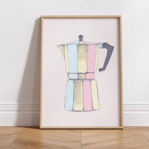 Könnte beinhalten: Gerahmter Druck einer bunten Kaffeemaschine. Die Illustration zeigt vertikale Streifen in Pastelltönen von Blau, Gelb und Rosa. Der Griff ist schwarz, und der Rahmen ist hellbraun. Der Hintergrund ist ein zartes Rosa.