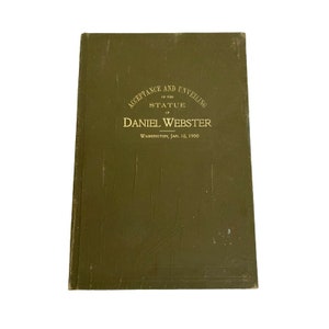 May include: A green book with gold lettering on the cover. The title is "Acceptance and Unveiling of the Statue of Daniel Webster" and the date is "Washington, Jan. 18, 1900".