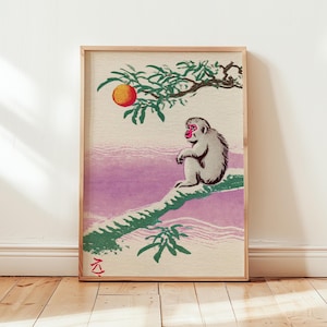 May include: A framed print of a Japanese-style illustration. A gray monkey sits on a green branch, with a red-faced monkey looking at an orange fruit. The background features purple and white hues.