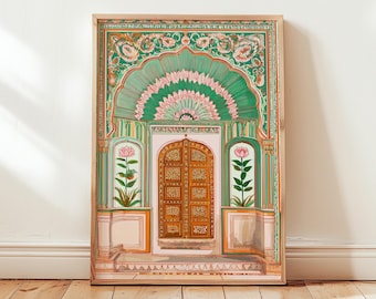 May include: A framed print of an Indian palace entrance. The artwork features a detailed depiction of a wooden door, framed by ornate archways and floral patterns in shades of green, pink, and gold. The print is set against a white wall and wooden floor.