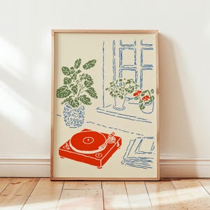 May include: A framed art print featuring a red record player, green potted plants, and a blue-lined window. The artwork has a minimalist style with a cream-colored background and a wooden frame. A stack of records is next to the record player.
