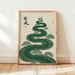 Peut inclure: Une affiche encadrée représentant une rivière verte stylisée serpentant vers le haut, avec des arbres stylisés le long des berges. Des caractères japonais sont imprimés en noir en haut à gauche. Le fond est crème, et le cadre est en bois clair.