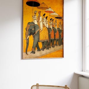 Op de afbeelding: Een antiek ingelijst schilderij dat een processie van olifanten met figuren onder kleurrijke paraplu's afbeeldt. Het kunstwerk heeft een warme gele achtergrond en gedetailleerde figuren in traditionele kledij, wat een historisch en cultureel thema oproept.