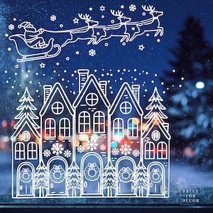 May include: White Christmas window cling featuring Santa Claus in a sleigh pulled by reindeer, above a row of houses and Christmas trees. Snowflakes and stars are scattered across the blue background. The words "Print for Decor" are in the bottom right corner.