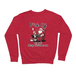 May include: Red Christmas jumper featuring a cartoon image of Santa Claus sitting in a chair, smoking a cigarette and holding a glass of liquor. The text on the jumper reads "F*ck Off oh, and Merry Christmas too".
