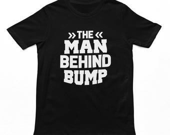 Puede incluir: Camiseta negra con texto blanco que dice "The Man Behind Bump".