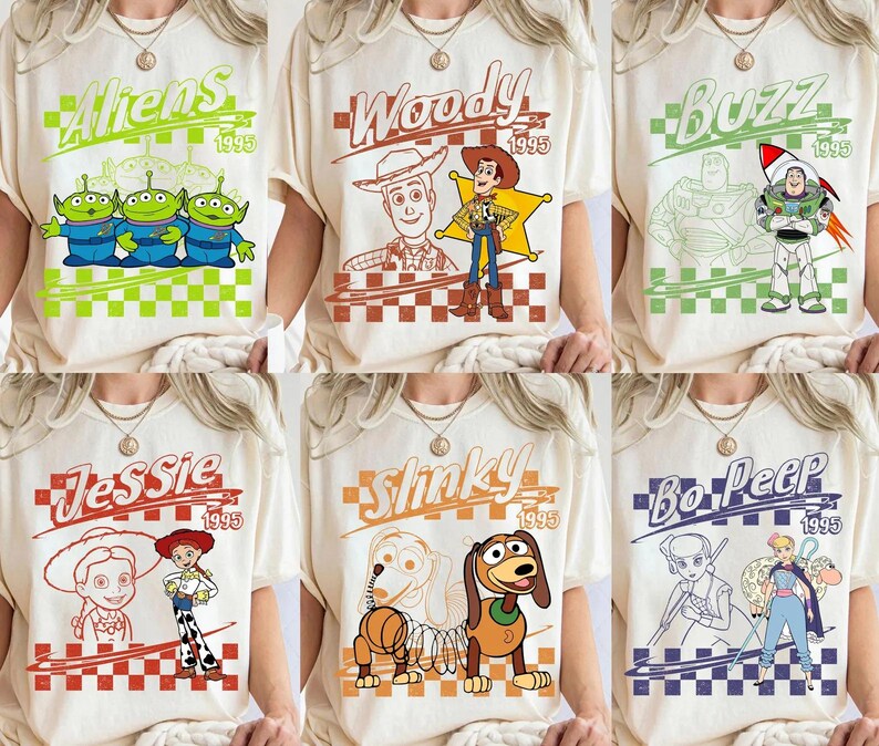 Może przedstawiać: Kolekcja sześciu kremowych koszulek, z kt&oacute;rych każda przedstawia inną postać z Toy Story, w tym Aliens, Woody, Buzz, Jessie, Slinky i Bo Peep, wraz z rokiem 1995 i nadrukowanym wzorem w szachownicę na przodzie każdej z nich.