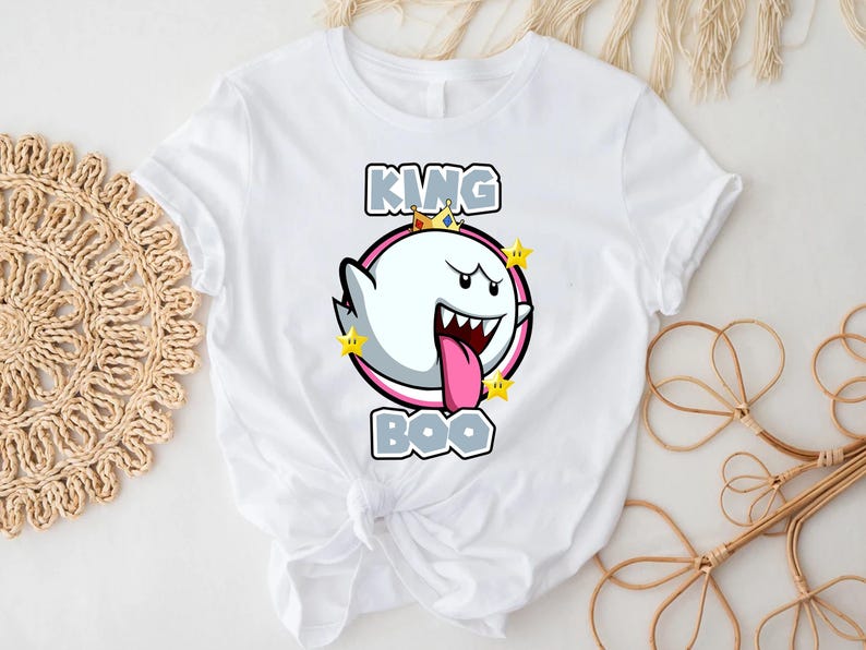 Op de afbeelding: Wit T-shirt met een afbeelding van King Boo uit de Super Mario-franchise. De afbeelding toont King Boo met een kroon en omringd door sterren. De tekst "KING BOO" is gedrukt in grijze letters.