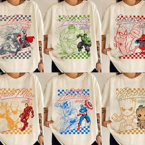 Puede incluir: Camisetas color crema con varios personajes de Marvel. Los dise&ntilde;os incluyen a Thor, Hulk, Spider-Man, Iron Man, Capit&aacute;n Am&eacute;rica y Groot, cada uno con un gr&aacute;fico y un a&ntilde;o &uacute;nicos. Las camisetas tienen un patr&oacute;n de cuadros en la parte superior e inferior.