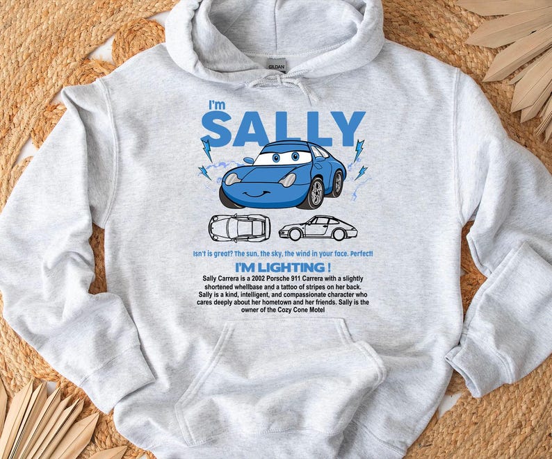 May include: A light gray hooded sweatshirt featuring a blue cartoon car with the text "I'm SALLY". The design includes lightning bolts and the phrase "I'M LIGHTING!". Additional text describes the car's character.