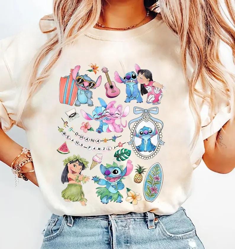 Może przedstawiać: Kremowy t-shirt z nadrukiem graficznym przedstawiającym postacie Stitcha i Lilo, deskę surfingową, gitarę, ananasa, kawałek arbuza, rożek lodowy oraz sznur lampek z napisem O-H-A-N-A M-E-A-N-S F-A-M-I-L-Y.