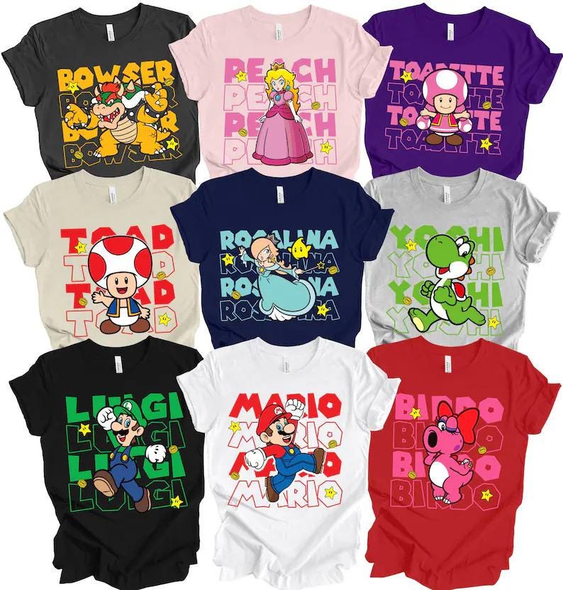 May include: A collection of nine short-sleeved t-shirts featuring various Nintendo characters including Bowser, Peach, Toadette, Toad, Rosalina, Yoshi, Luigi, Mario, and Birdo. Each shirt displays the character's name in a repeating block pattern.