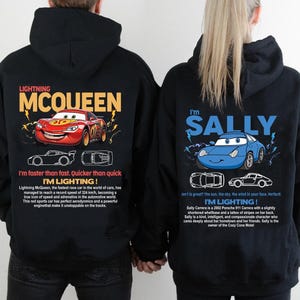 May include: Black hoodies featuring Lightning McQueen and Sally Carrera from the Cars movie. The Lightning McQueen hoodie has a red race car graphic with text. The Sally Carrera hoodie has a blue car graphic with text.