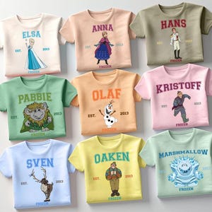 May include: Nine colorful t-shirts featuring characters from the movie "Frozen." Each shirt displays a character's name, an illustration, and the word "FROZEN." The shirts are in various colors, including blue, pink, green, and yellow.