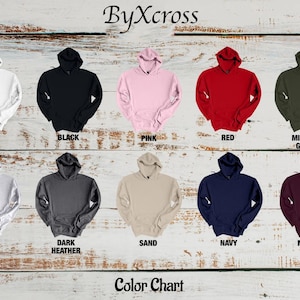 May include: A color chart displays various hooded sweatshirts in multiple colors, including white, black, pink, red, military green, ash, dark heather, sand, navy, and maroon. The text "ByXcross" and "Color Chart" are also visible.