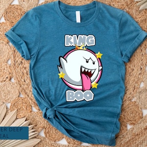 Op de afbeelding: Een tealblauw t-shirt met een afbeelding van King Boo uit de Super Mario-franchise. De afbeelding toont King Boo met een kroon en de tekst "King Boo" eronder.