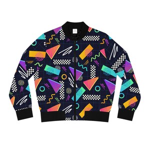 Könnte beinhalten: Eine schwarze Bomberjacke mit einem farbenfrohen geometrischen Muster. Das Muster enthält Dreiecke, Quadrate, Kreise und Wellenlinien in den Farben Pink, Blau, Grün, Gelb und Orange.