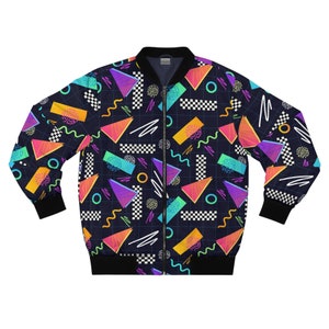 Puede incluir: Una chaqueta bomber negra con un estampado geométrico colorido. El estampado incluye triángulos, cuadrados, círculos y líneas onduladas en tonos de rosa, azul, amarillo y verde.