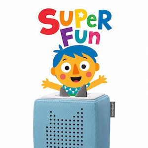 Op de afbeelding: Een lichtblauwe, met stof beklede luidsprekerbox met een Toniebox-label aan de zijkant. Een uitgesneden figuur met blauw haar en een oranje gezicht is bovenop bevestigd, onder de kleurrijke tekst die SUPER FUN spelt.