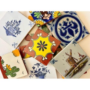 May include: A collection of square ceramic tiles featuring diverse hand-painted designs including a blue floral basket, a yellow starburst pattern, a windmill landscape, a cactus with a sun, and intricate blue and white circular geometric motifs.