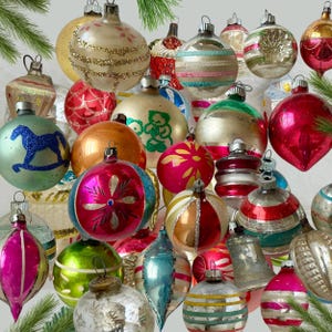 May include: A collection of vintage glass Christmas ornaments in various shapes and sizes. The ornaments feature diverse colors including red, green, gold, silver, and blue, with painted details, glitter accents, and metallic finishes.