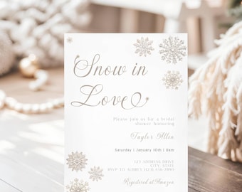 May include: A white rectangular bridal shower invitation card featuring the text Snow in Love in a script font, accompanied by gold-toned snowflake illustrations. The card includes details for Taylor Allen on Saturday, January 10th at 11am.