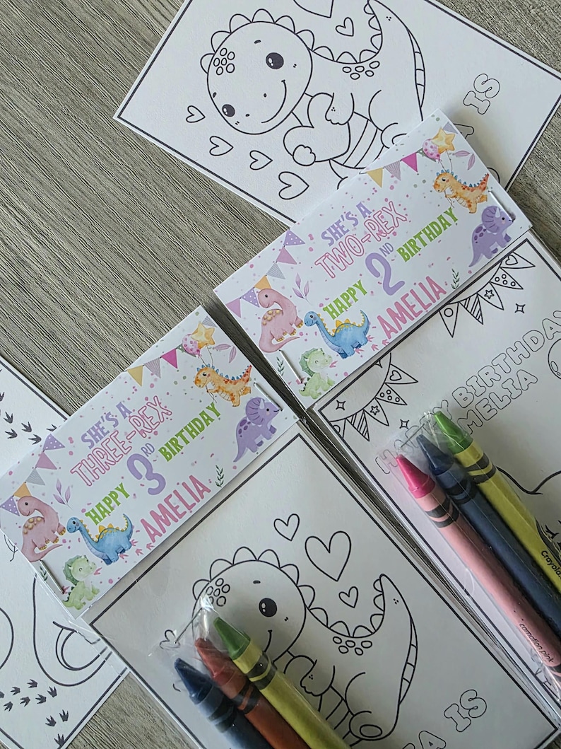 May include: A collection of children's birthday party favors. The favors include coloring pages with dinosaur illustrations and crayon packs. The packaging features text that reads "She's a Two-Rex 2nd Birthday Amelia" and "She's a Three-Rex 3rd Birthday Amelia."