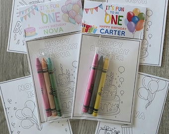 May include: A collection of birthday-themed coloring pages and crayon sets. The pages feature the phrases "Happy Birthday" and "It's Fun to be One", along with birthday cake and balloon illustrations. Each set includes a small pack of crayons.