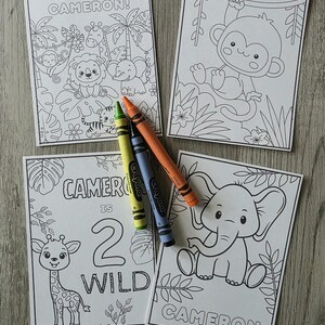 May include: Four coloring pages with jungle animal illustrations and the name "Cameron". One page says "Happy Birthday Cameron!" and another says "Cameron is 2 Wild". Crayons in yellow, green, blue, and orange are included.