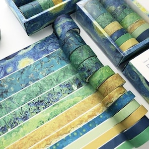 K&ouml;nnte beinhalten: Ein Set mit 12 Washi-Tapes mit verschiedenen Designs, inspiriert von Vincent van Goghs Gem&auml;lde &bdquo;Sternennacht&ldquo;. Die Tapes sind in verschiedenen Farben, darunter Blau, Gr&uuml;n, Gelb und Wei&szlig;. Die Tapes sind in einer Schachtel mit einem &bdquo;Sternennacht&ldquo;-Design verpackt.