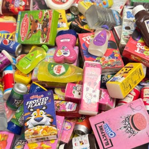 Può includere: Una collezione di repliche in miniatura di prodotti alimentari e per la casa. Include scatole di cereali, lattine di bevande e bottiglie di sapone e lozione. La scatola di Kellogg's Frosted Flakes presenta Tony the Tiger.