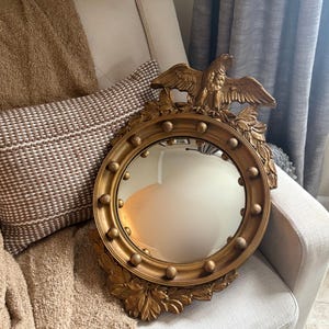 May include: A white ceramic mug with a black handle and the text "But First, Coffee" in a black, bold font. The mug is on a white surface.