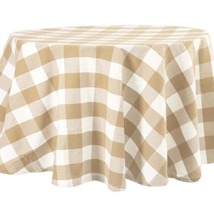 May include: A round tablecloth with a tan and white checkered pattern. The fabric drapes over a surface, showcasing the large-scale gingham design. This tablecloth is suitable for dining and adds a classic touch to any table setting.