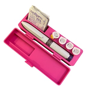 May include: A vibrant pink medical device case, open to show a white and grey medical pen, alcohol wipes, and several small, white CarePoint containers. The case is rectangular with a hinged lid and a snap closure.