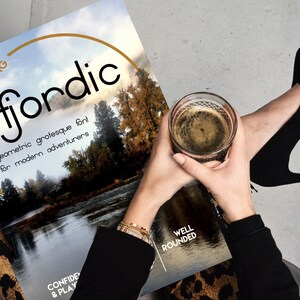 May include: A book cover with the title "Introducing fjordic" in a bold, geometric font. The text below reads "geometric grotesque font for modern adventurers". The cover features a photo of a river flowing through a forest.