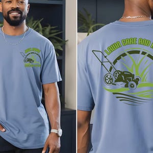 May include: A light blue t-shirt featuring a small graphic on the front left chest and a large graphic on the back. Both graphics depict a lawn mower with green grass and the text "LAWN CARE AND MORE" in a circular design.