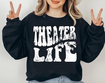 May include: Black sweatshirt with white text that reads "Theater Life" in a retro font style.
