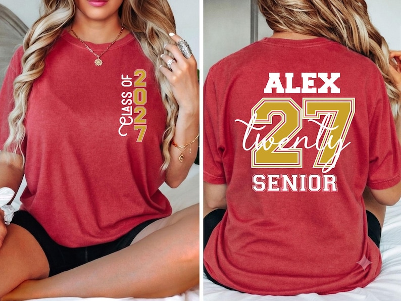 Może przedstawiać: Czerwony t-shirt z kr&oacute;tkim rękawem z napisem "CLASS OF 2027" w kolorze złotym na lewej piersi. Z tyłu znajduje się imię "ALEX" na biało, liczba "27" na złoto, słowo "twenty" białą kursywą oraz napis "SENIOR" w kolorze białym.