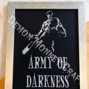 Puede incluir: Un bordado de punto de cruz en blanco y negro de una figura que sostiene un arma con el texto "Army of Darkness" debajo.