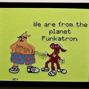 May include: Cross-stitch artwork featuring two cartoon characters with the text "We are from the planet Funkatron." The characters are wearing sunglasses and have a green background.