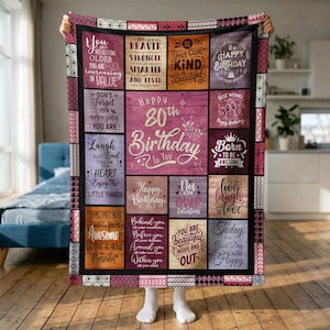 May include: A rectangular throw blanket featuring a patchwork design of various inspirational quotes and birthday messages in shades of purple, pink, and brown. The center panel displays the text Happy 80th Birthday To You with decorative stars and confetti graphics.