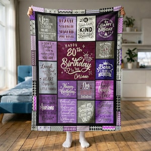 May include: A rectangular throw blanket featuring a purple and grey patchwork design with various inspirational quotes and the text Happy 80th Birthday To You Corinne. The blanket has a decorative border with geometric patterns in black and white.