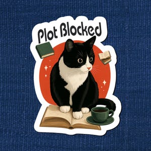 May include: A sticker featuring a black and white cat sitting on an open book with a cup of coffee. The text "Plot Blocked" is above the cat. Small books and stars are also in the design. The cat has a white chest and face.