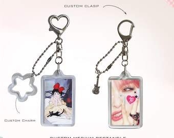 May include: Two custom medium rectangle photo charm keychains with silver-toned hardware. One features a heart-shaped clasp and a star charm, the other a standard clasp and a guitar charm. Each displays a unique photo insert within a clear frame.