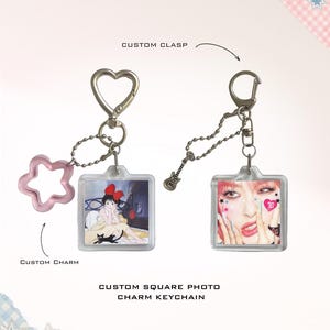 May include: Two custom square photo charm keychains with silver hardware. The left keychain features a heart-shaped clasp, a pink star charm, and an anime illustration. The right keychain has a guitar charm and a portrait of a person with pink hair.